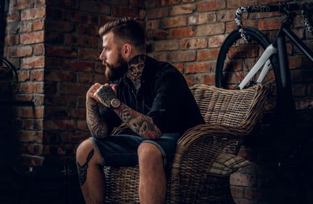 a bearded hipster male model with tattoos