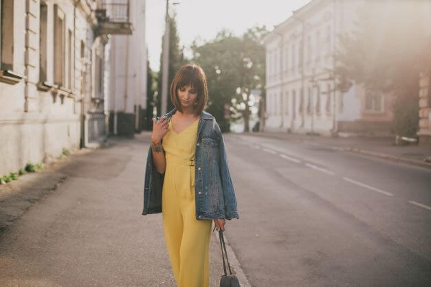 a women in a Yellow jumpsuit paired with a denim jacket