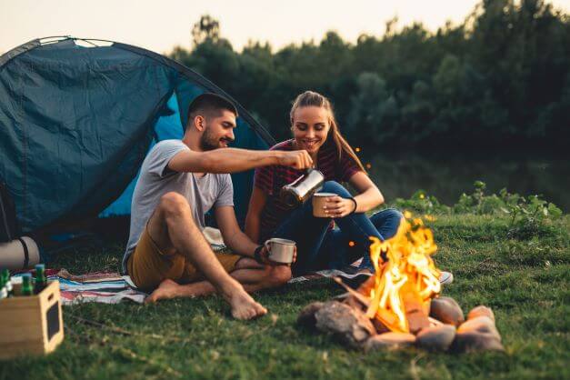 Couple wild camping with fire