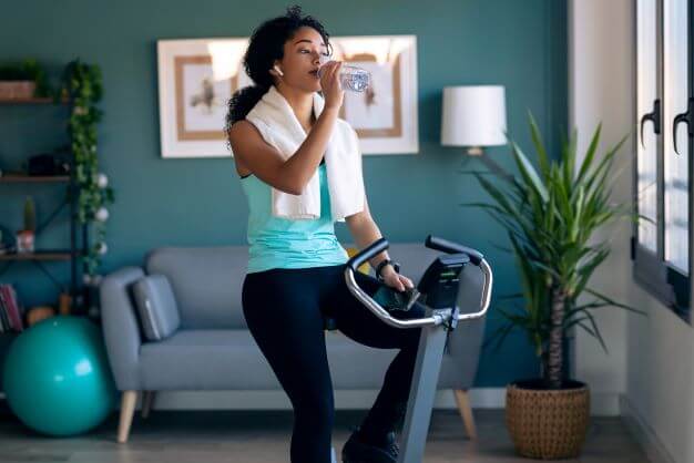 woman uses exercise bike at home
