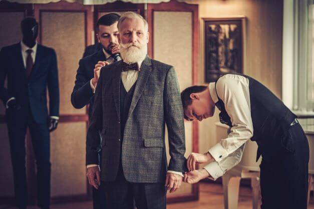 Tailors making three piece suits for an older gentleman