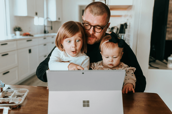 Dad with kids researching family holidays online