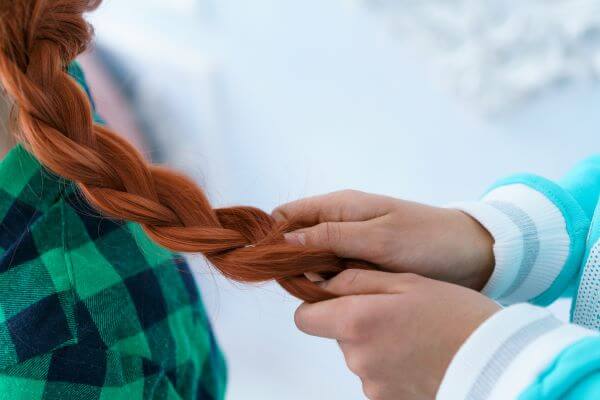 The fishtail braid on lovely auburn hair